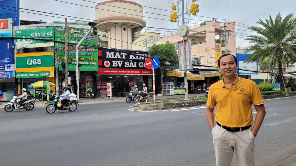 Tuấn Golden đứng trên đường Trần Hưng Đạo, tuyến xuyên qua nội ô Long Xuyên trước khi có đường tránh